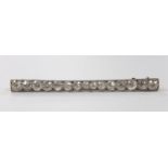 A 1920's white metal and millegrain set fifteen stone diamond bar brooch, 55mm, gross weight 4.6