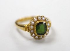 An Edwardian 18ct gold, green tourmaline and split pearl set oval cluster ring, size S, gross weight