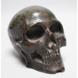 A bronze model of a skull, once part of a larger piece. 13cm deep