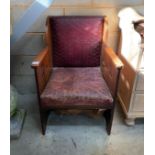 An early 20th century Arts & Crafts oak armchair, with pierced sides and embossed leather seat and