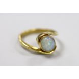 An 18ct and single stone oval white opal set ring, with crossover shoulders, size Q, gross weight
