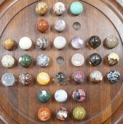 A large mahogany solitaire board with large specimen hardstone marbles, 42cm