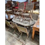 A weathered teak folding oval garden table, length 150cm, depth 91cm, height 74cm together with