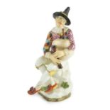 A Meissen porcelain figure of a seated bagpiper, mid 18th century, modelled by J.J. Kandler, wearing
