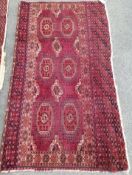 A Tekke burgundy ground rug, 135 x 77cm, worn