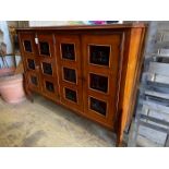 A mid century continental side cabinet, the panelled doors carved with antelope and exotic birds,