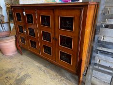 A mid century continental side cabinet, the panelled doors carved with antelope and exotic birds,