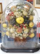 A Victorian display of papier mache fruit in a basket, under a glass dome, 55cms high