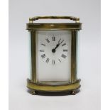 A French oval brass carriage timepiece, 11cms high