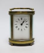 A French oval brass carriage timepiece, 11cms high