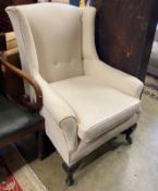 An early 20th century upholstered wing armchair, width 76cm, depth 78cm, height 102cm