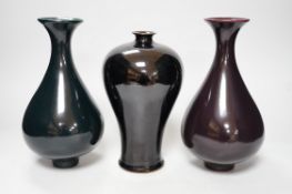 A Chinese black ground plum vase, together with a near pair of Chinese vases, tallest 24cm