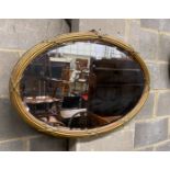 An Edwardian oval giltwood and composition wall mirror, width 86cm, height 56cm