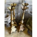 A set of four large brass candlesticks, height 74cm