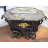 A Victorian gilt lacquer coal scuttle on wheels with glass inset top, 63cm long