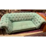 A Victorian double drop arm Chesterfield settee upholstered in a deep buttoned green fabric,