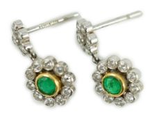 A modern pair of 18ct white gold, emerald and diamond cluster set drop earrings, 16mm, gross