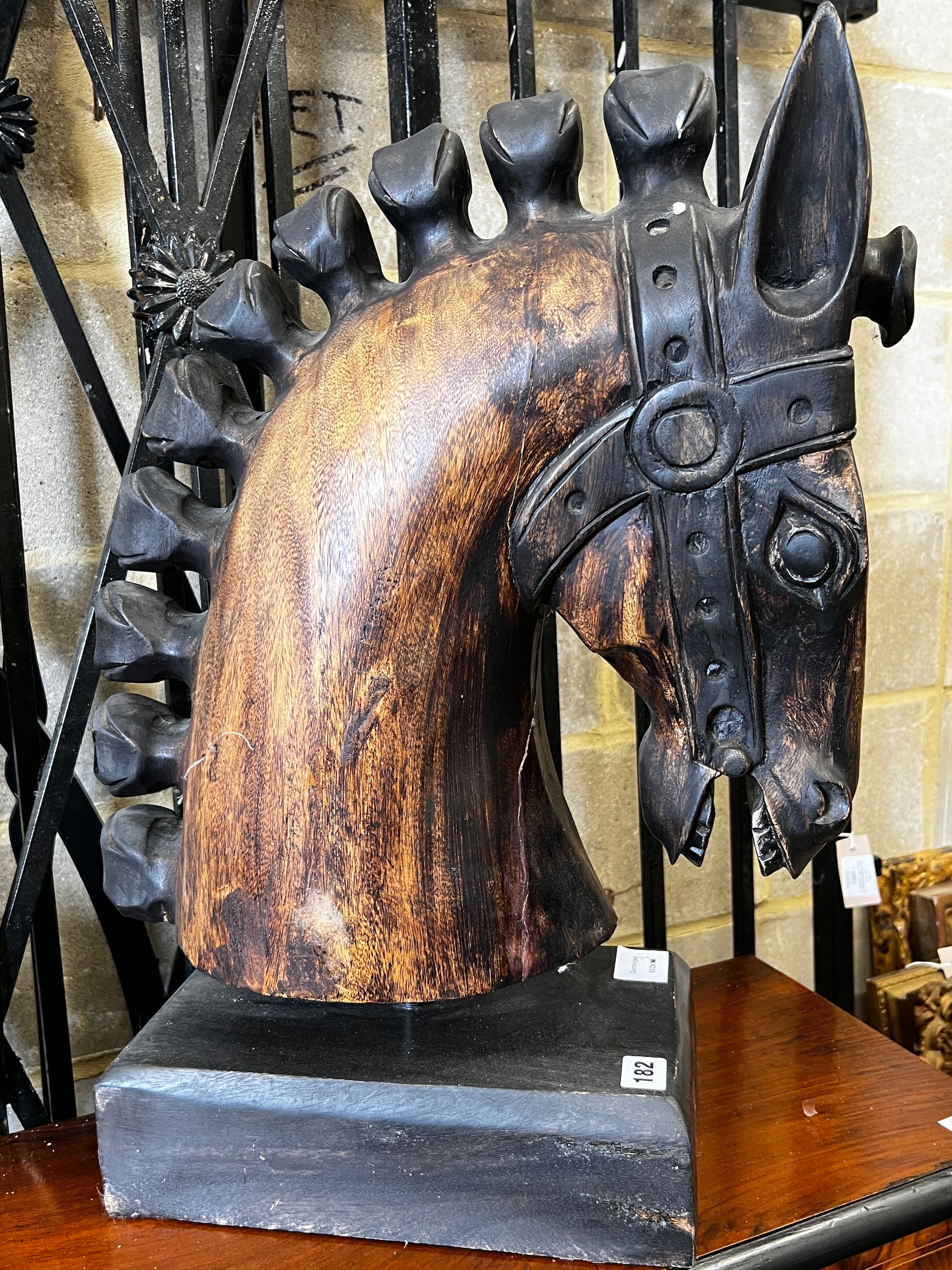 A stylised carved wood model of a horse's head on rectangular plinth, height 59cm