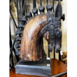 A stylised carved wood model of a horse's head on rectangular plinth, height 59cm