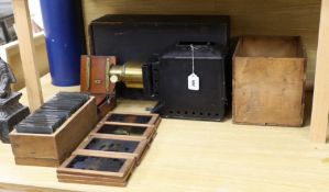 A magic lantern and a quantity of glass slides, including eleven novelty moving painted slides