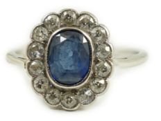 A white metal, sapphire and diamond set oval cluster ring, size M/N, gross weight 2 grams.