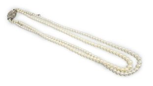 Two single strand graduated cultured pearl necklaces, both with diamond set white or yellow metal
