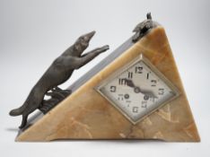 An Art Deco triangular marble and spelter clock, mounted with a fox chasing a bird, 39cms wide