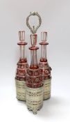 A Victorian three bottle ruby flashed glass and electroplate decanter stand, overall 46cms high