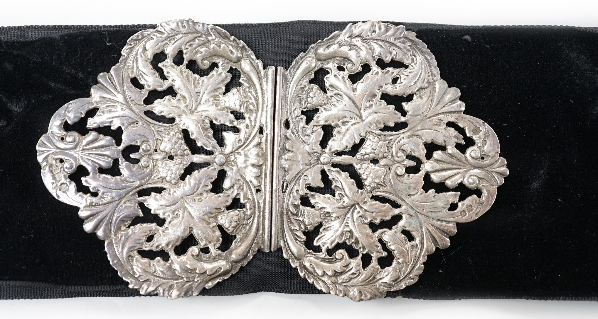 A late Victorian pierced silver belt buckle, on a black sash belt, James Deakin & Sons, Chester,