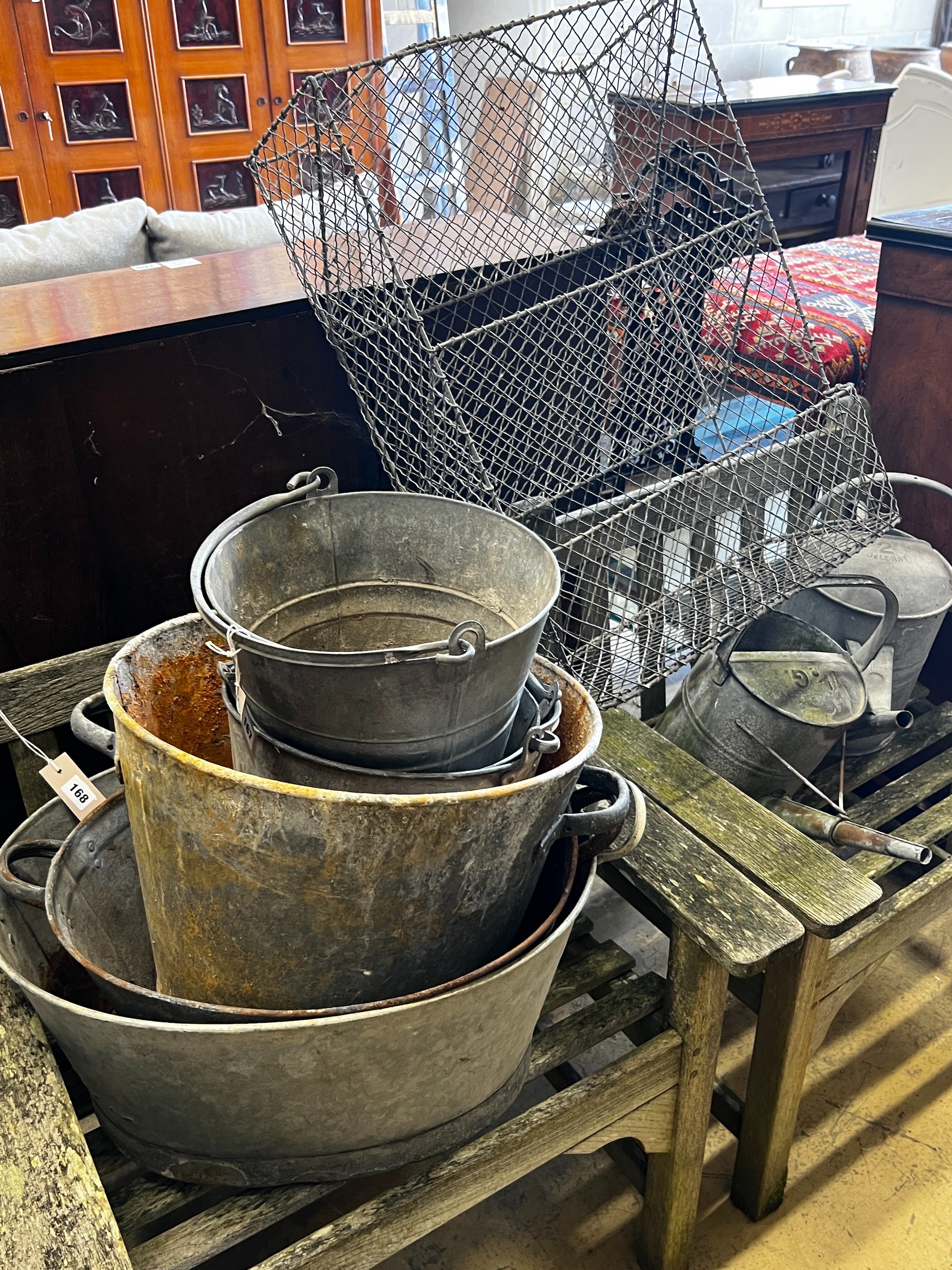 Eight assorted galvanised buckets, tubs and watering cans and a wirework rack