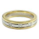 A modern Simbol two colour 18ct gold and gypsy set three stone diamond band, size M, gross weight