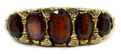 A 1960's Victorian style 9ct gold and graduated five stone garnet set half hoop ring, with diamond