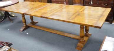 A reproduction 18th century style oak extending refectory dining table, length 306cm extended, one