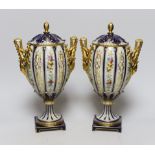 A pair of 19th century continental porcelain gilt and floral urns and covers, 29cms high