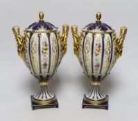 A pair of 19th century continental porcelain gilt and floral urns and covers, 29cms high