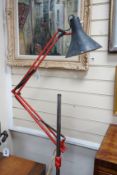 A converted industrial style anglepoise standard lamp on cast metal wheeled stand