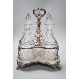 A decorative three bottle decanter set, on lion feet tripod plated stand. 37cm tall