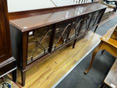 An Edwardian glazed mahogany dwarf bookcase, enclosed by six astragal glazed sliding doors, width