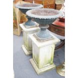 A pair of Victorian painted cast iron campana garden urns on square stone plinths, diameter 51cm,