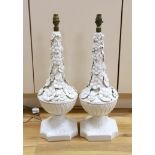 A pair of white glazed floral encrusted lamps, 58cms high not including light fitting