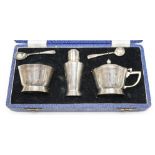 A cased George VI Art Deco silver three piece condiment set and two matching spoons, Mappin &