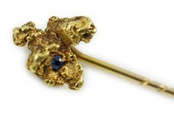 A late Victorian yellow metal and single stone sapphire set 'nugget' stick pin, 62mm, gross weight