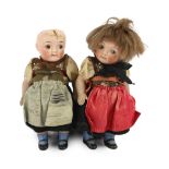 A pair of German all-bisque dolls with 'googlie' eyes, jointed at the hip and shoulder, the feet