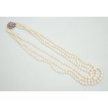 A 1960's triple strand graduated cultured pearl necklace, with 9ct white gold, ruby and diamond chip