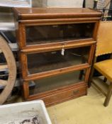 A Globe Wernicke oak three section bookcase with base drawer, width 86cm, depth 27cm, height 114cm