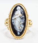 An early 20th century yellow metal and black sardonyx set cameo ring, carved with the figure of a