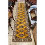 An Afghan gold ground geometric runner, 400 x 85cm