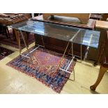 A contemporary rectangular plate glass topped console table, with a stainless steel base, length