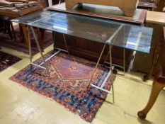 A contemporary rectangular plate glass topped console table, with a stainless steel base, length