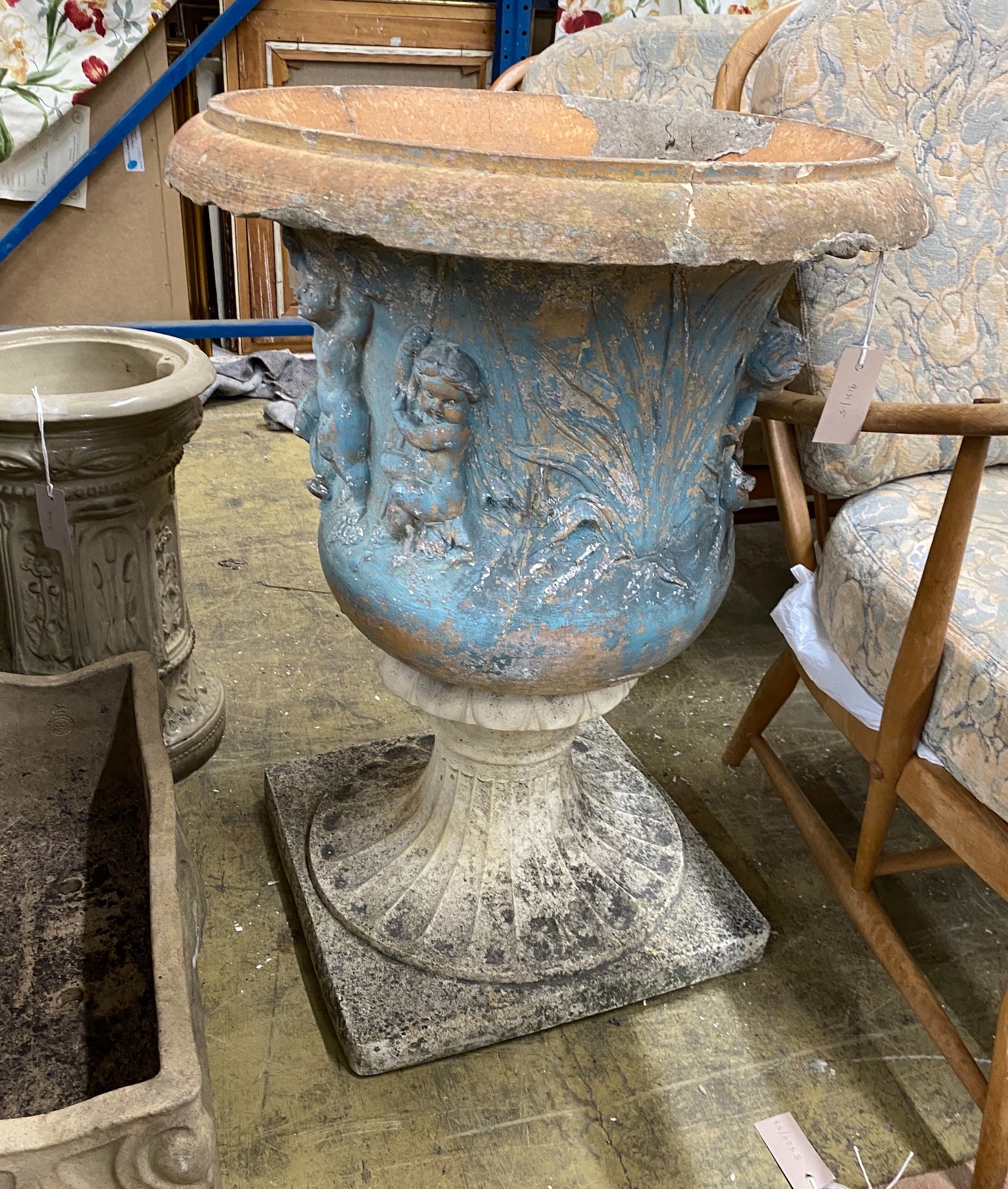 A reconstituted stone campana garden urn on a later composite base, diameter 58cm, height 76cm